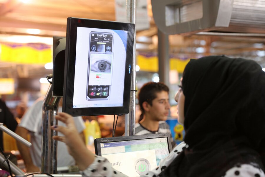 A Syrian woman in Jordan’s Azraq refugee camp uses iris scan technology to access her WFP electronic food voucher.